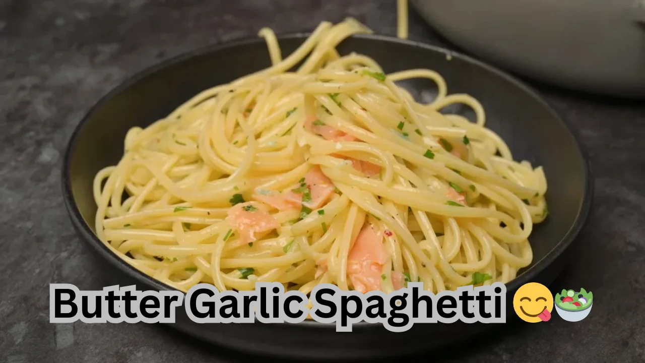 A plate of butter garlic spaghetti garnished with parsley, showcasing a delicious, creamy pasta dish ready to enjoy.