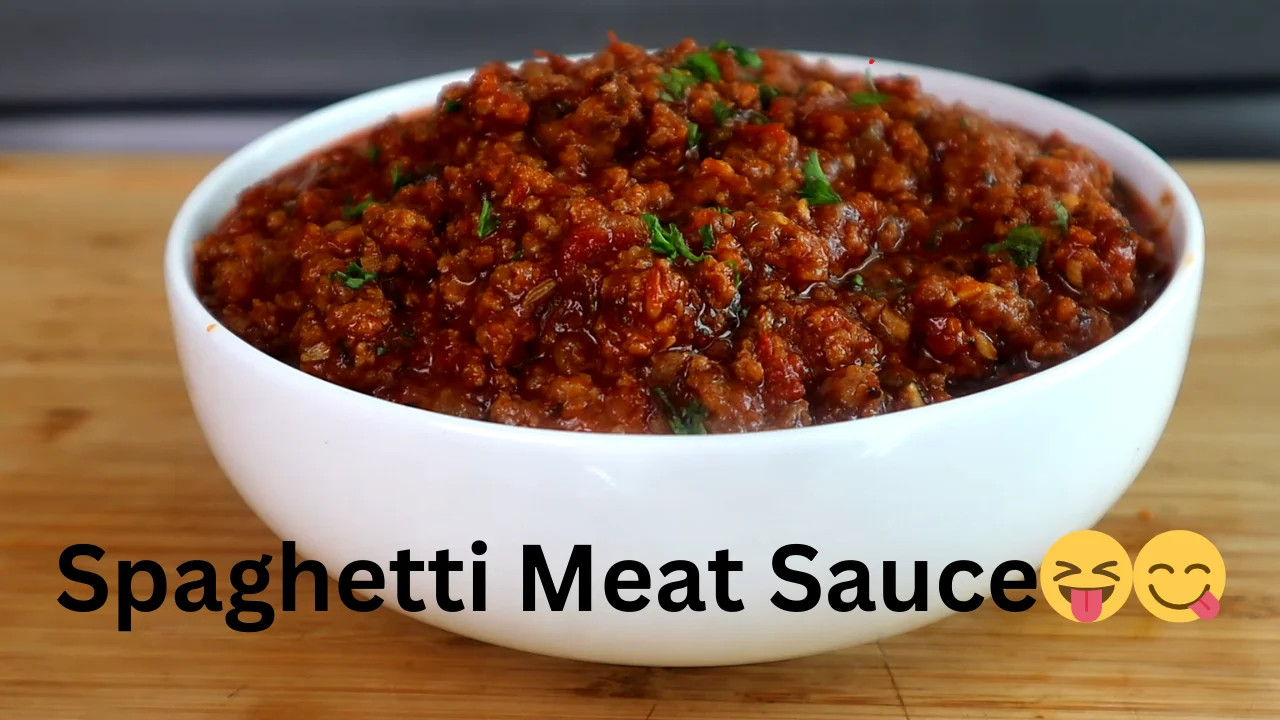 A delicious plate of Spaghetti Meat Sauce topped with rich meat sauce, garnished with fresh herbs and grated cheese.