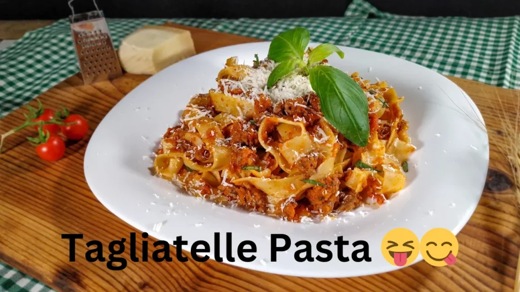 A bowl of tagliatelle pasta, featuring long, flat strands, garnished with herbs and a drizzle of olive oil.
