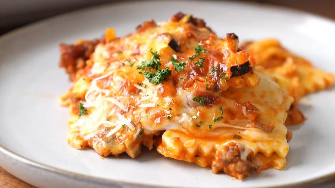 Baked Ravioli Lasagna 2 A vibrant dish of backed ravioli lasagna, featuring golden pasta layers, marinara sauce, and a sprinkle of fresh herbs.