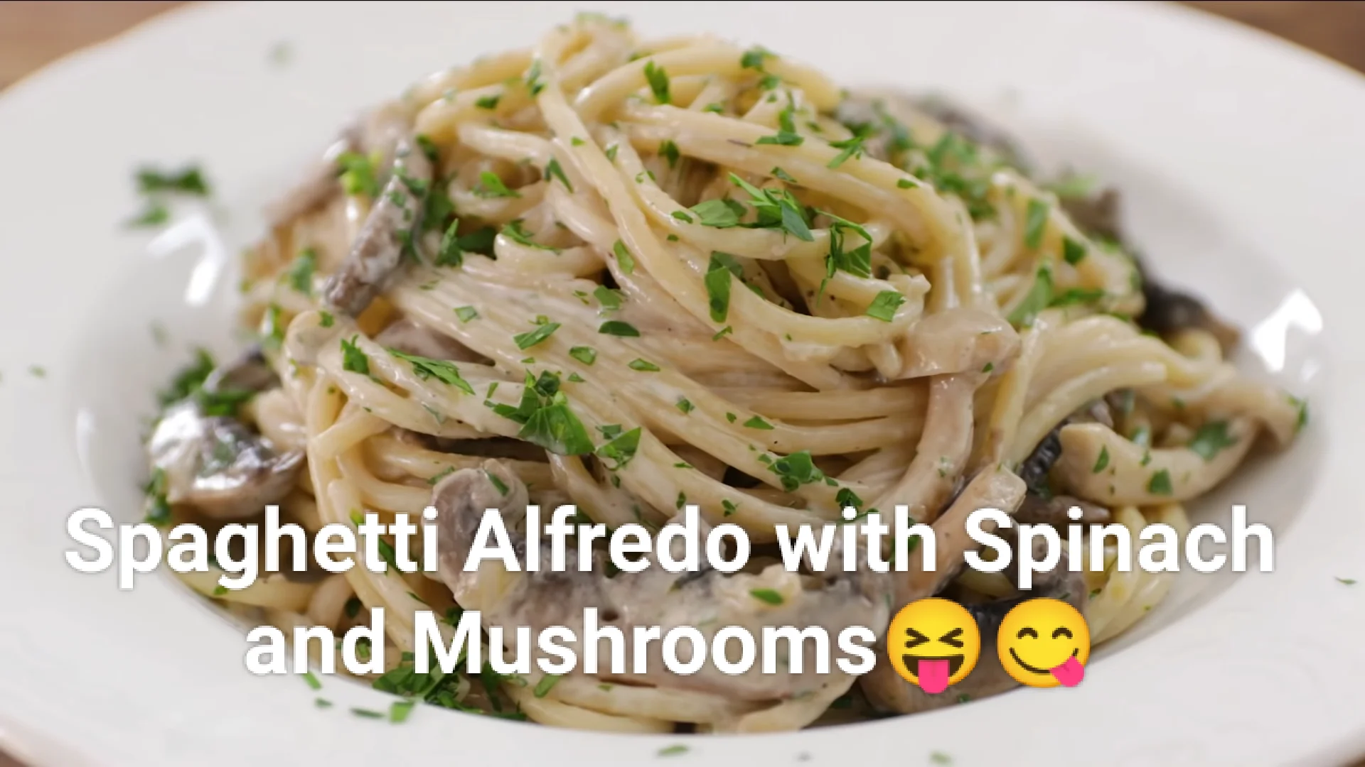 Spaghetti alfredo featuring creamy sauce, fresh spinach, and mushrooms, served in a bowl.