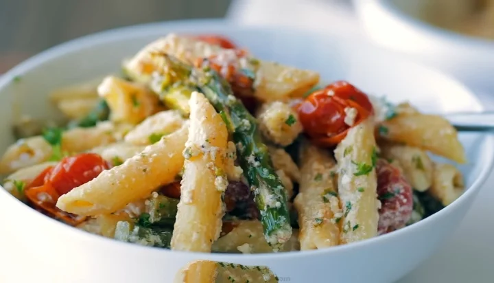 Spinach feta tomato pasta served in a bowl, showcasing vibrant colors and fresh ingredients.