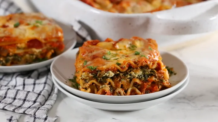 Vegetarian Spinach Lasagna 2 Vegetarian spinach lasagna featuring layers of spinach, cheese, and marinara sauce in a baking dish.
