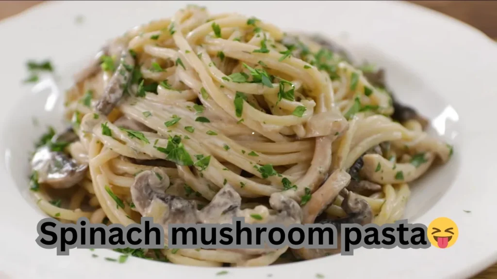 A delicious bowl of spinach mushroom pasta, garnished with herbs and cheese, ready to be served.